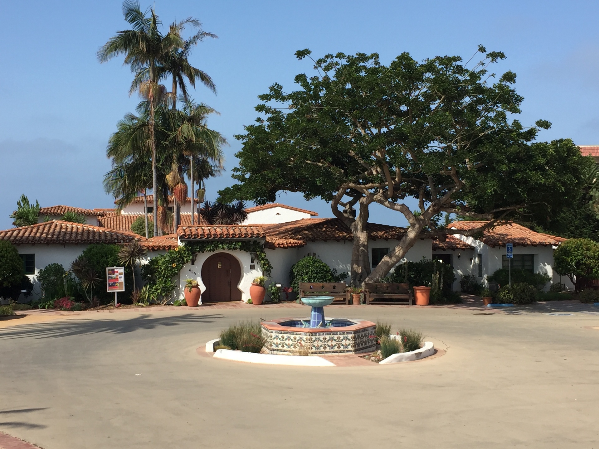 Mediterranean-style building with tile roof and courtyard fountain