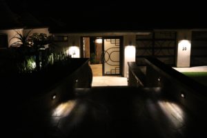 Modern home entry with landscape and step lighting at night