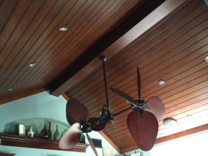 Wood-clad vaulted ceiling with dual ceiling fans and recessed lights