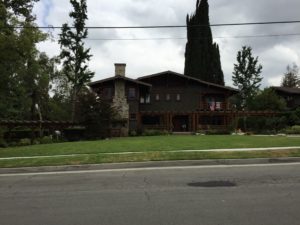Craftsman home with wraparound porch and stone chimney